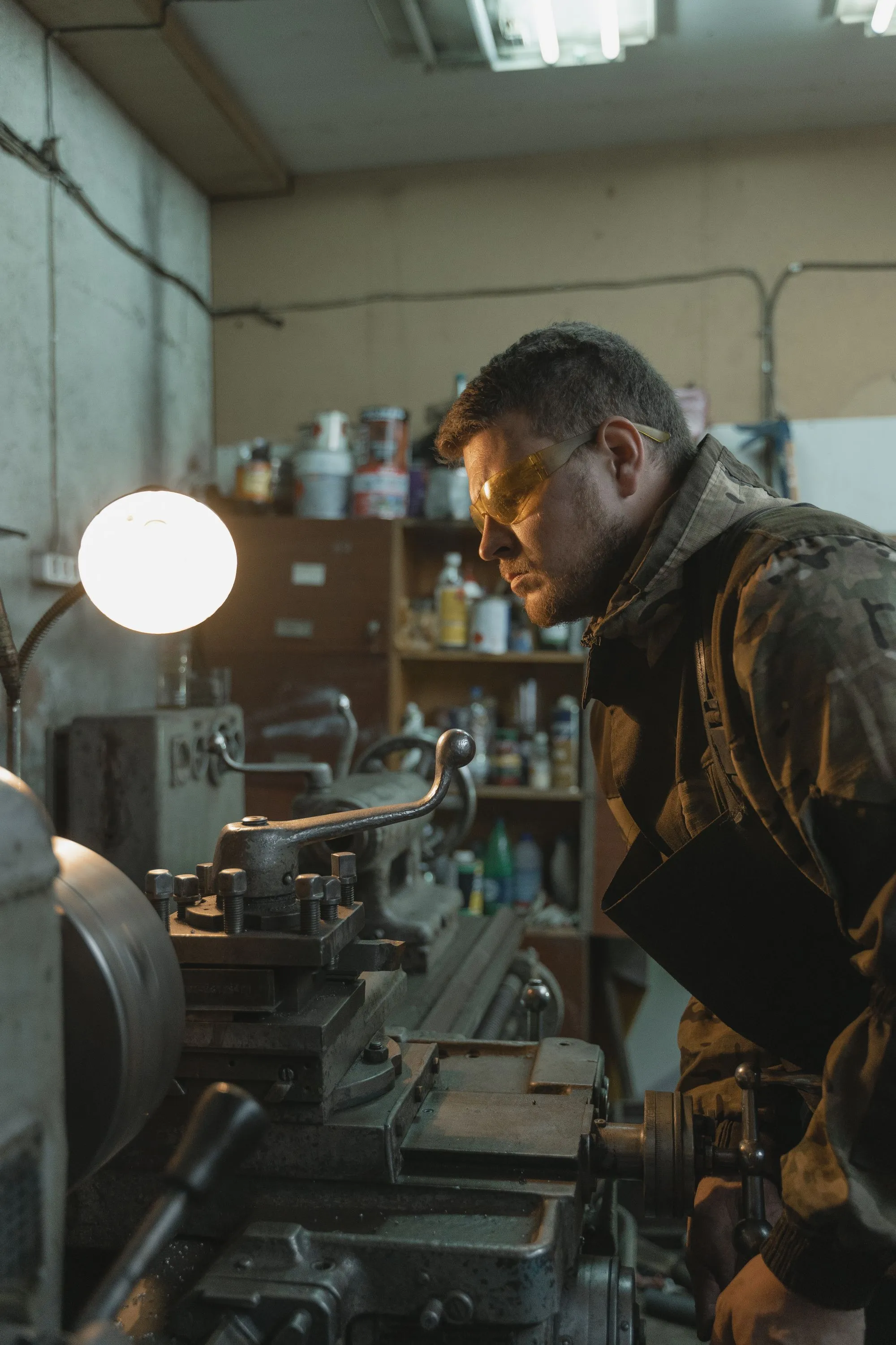 Lathe operator wearing protective eyewear in a machine shop